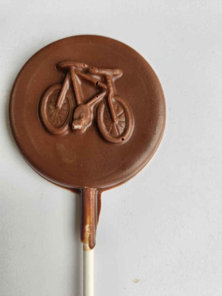 A solid chocolate sucker with the image of a bike on it.