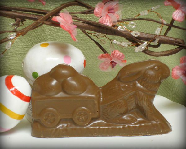 A 3d solid chocolate rabbit pulling a cart
